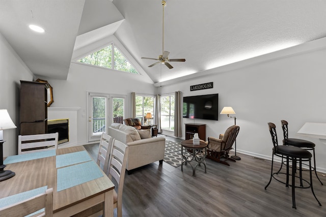 living room featuring a textured ceiling, ceiling fan, high vaulted ceiling, and dark hardwood / wood-style flooring