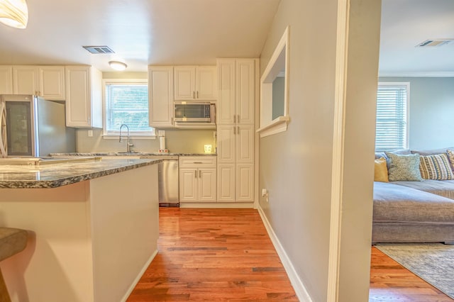 kitchen with sink, appliances with stainless steel finishes, and light hardwood / wood-style floors