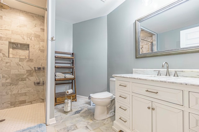 bathroom featuring tiled shower, toilet, and vanity