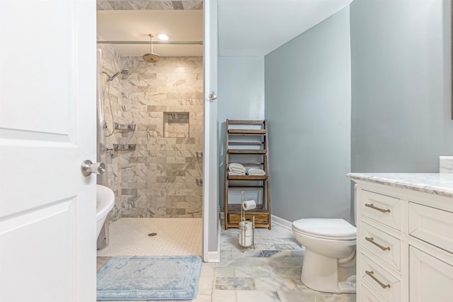 bathroom featuring tiled shower, vanity, and toilet