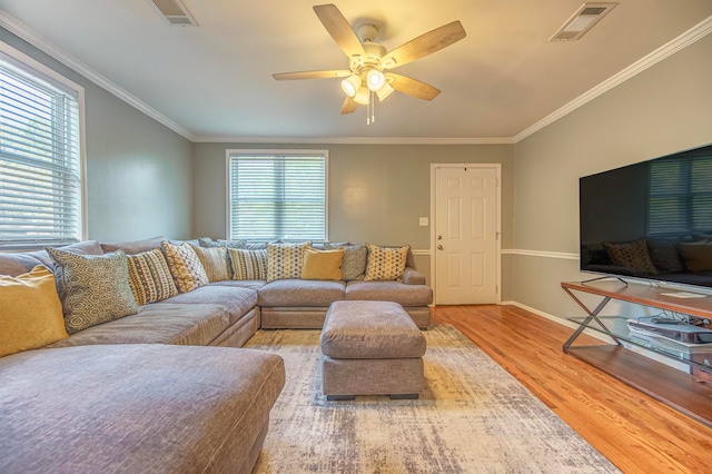 living room featuring light hardwood / wood-style flooring, ceiling fan, and ornamental molding