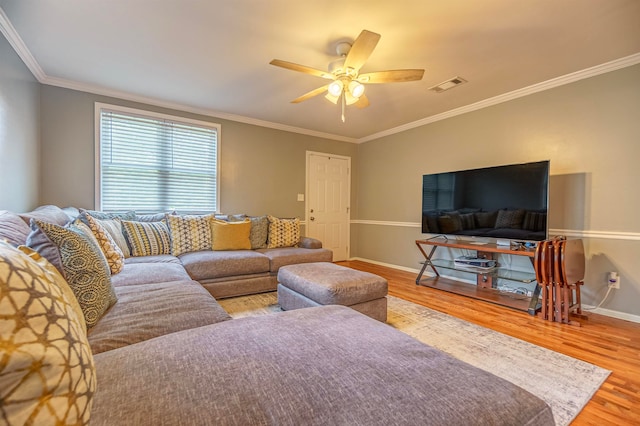 living room with crown molding, wood-type flooring, and ceiling fan