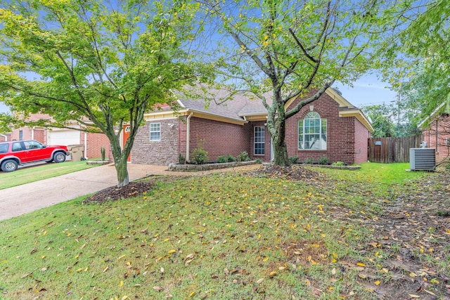 ranch-style house with a garage, a front lawn, and central air condition unit