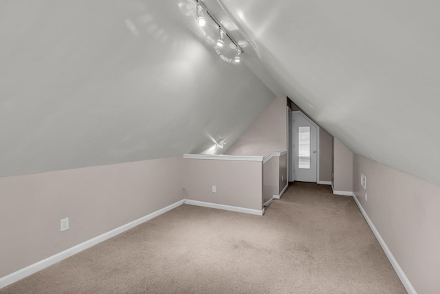 bonus room featuring lofted ceiling and light carpet