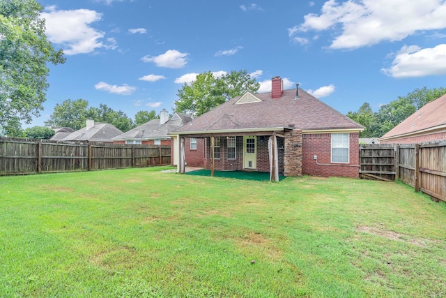 rear view of house with a patio and a yard