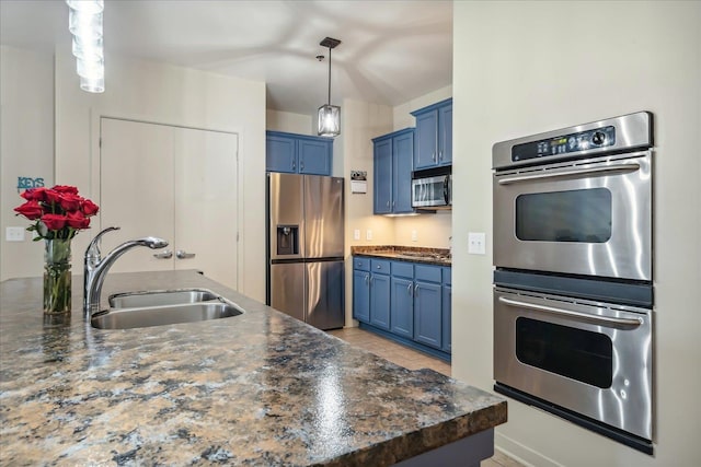 kitchen featuring blue cabinetry, pendant lighting, appliances with stainless steel finishes, and sink