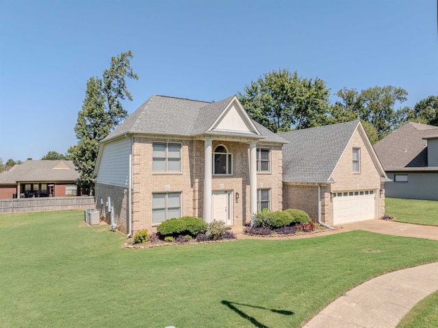 view of front of house featuring cooling unit, a front yard, and a garage