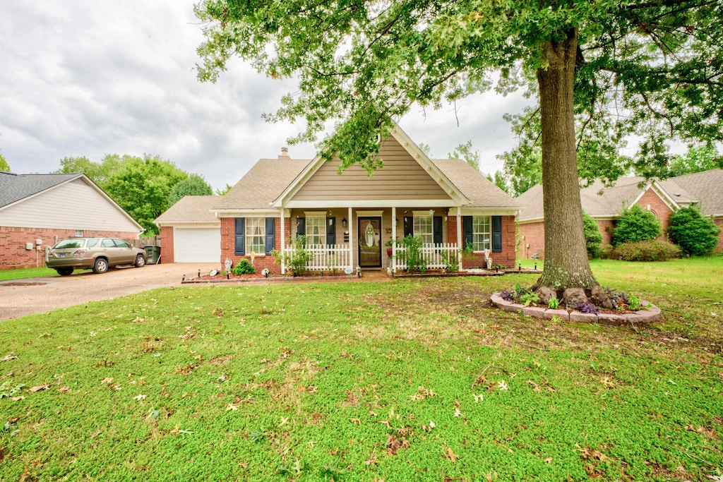 view of front of home with a porch, a garage, and a front yard