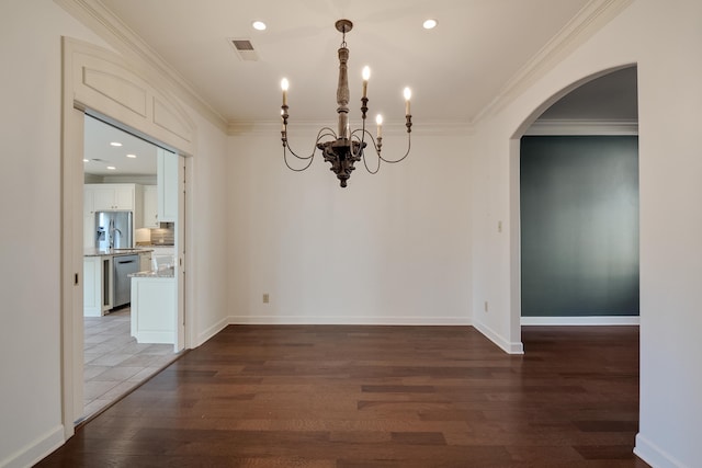 unfurnished dining area with ornamental molding, sink, dark wood-type flooring, and a notable chandelier