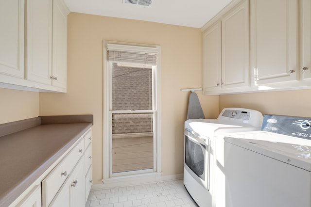 washroom featuring light tile patterned floors, independent washer and dryer, and cabinets