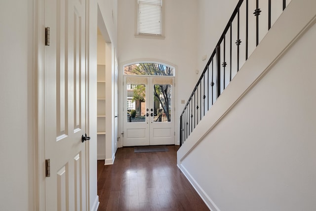 foyer entrance featuring a high ceiling, dark wood-type flooring, and french doors