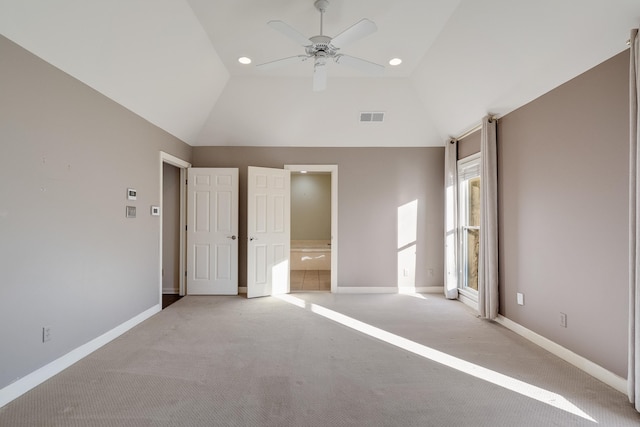 unfurnished bedroom featuring ceiling fan, light colored carpet, ensuite bathroom, and high vaulted ceiling