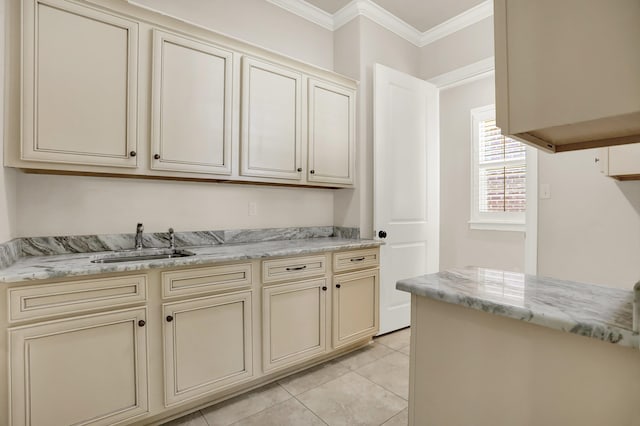 kitchen featuring light tile patterned floors, ornamental molding, sink, cream cabinetry, and light stone countertops