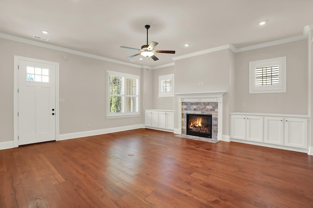 unfurnished living room with a healthy amount of sunlight, a fireplace, dark wood-type flooring, and ceiling fan