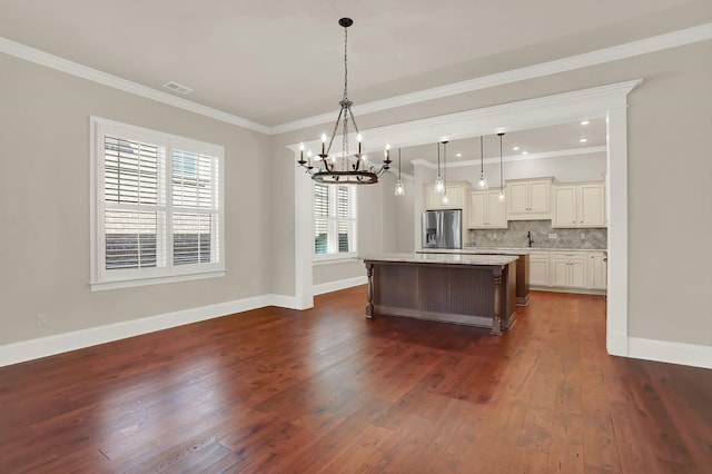 kitchen featuring decorative light fixtures, stainless steel fridge, dark hardwood / wood-style flooring, and a kitchen island