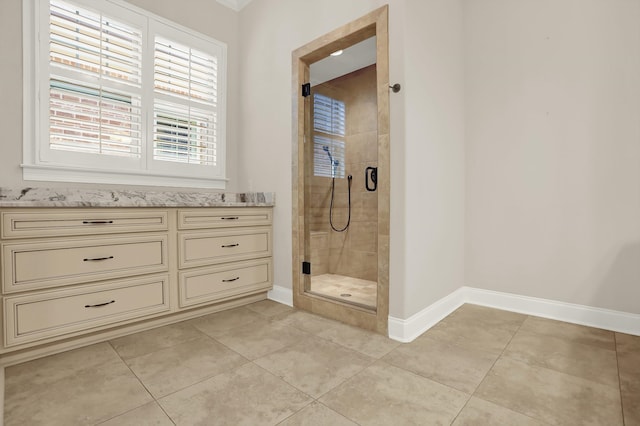 bathroom featuring tile patterned flooring, walk in shower, and vanity