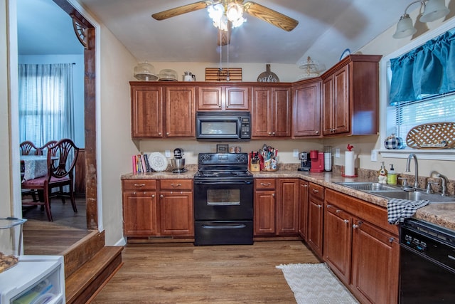 kitchen with vaulted ceiling, black appliances, ceiling fan, light hardwood / wood-style flooring, and sink