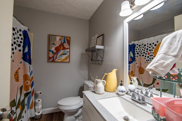 bathroom featuring a textured ceiling, hardwood / wood-style floors, vanity, and toilet