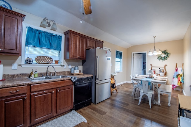 kitchen featuring pendant lighting, lofted ceiling, dark wood-type flooring, dishwasher, and stainless steel refrigerator