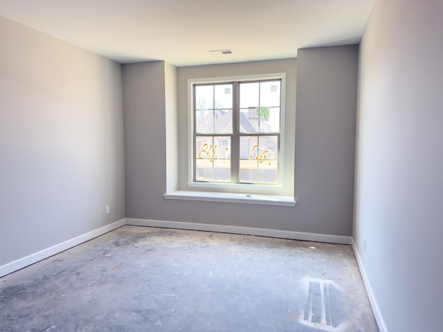 empty room with concrete floors and baseboards