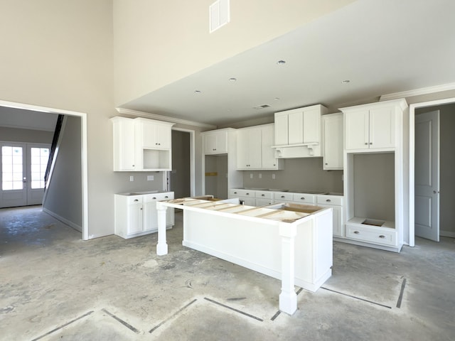 kitchen with concrete flooring, french doors, visible vents, and a center island