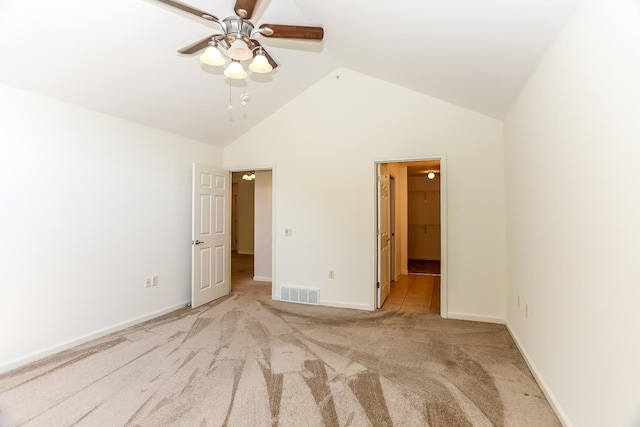 unfurnished bedroom featuring a spacious closet, high vaulted ceiling, a closet, ceiling fan, and light carpet