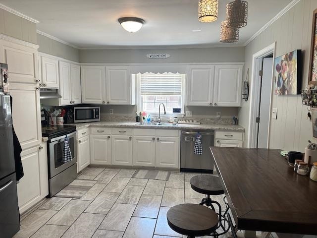 kitchen with appliances with stainless steel finishes, crown molding, white cabinetry, and sink