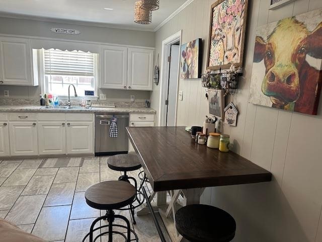 kitchen with light stone counters, sink, stainless steel dishwasher, white cabinetry, and crown molding