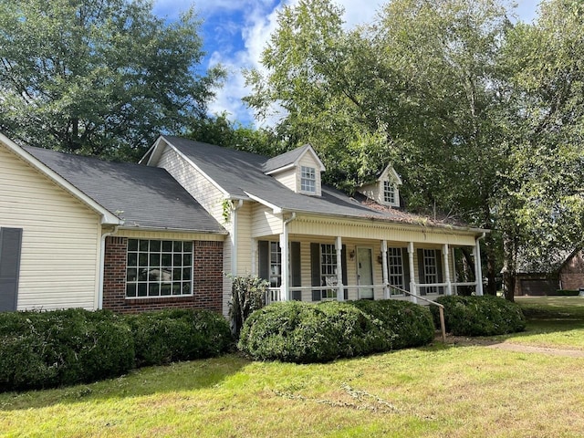 cape cod home featuring a front yard and a porch