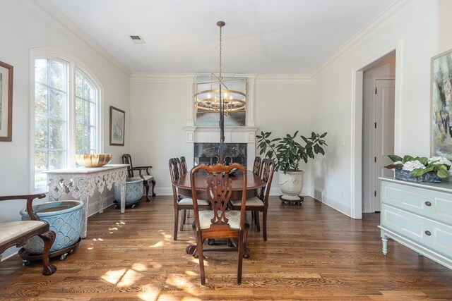 dining room with dark hardwood / wood-style floors, a chandelier, and crown molding