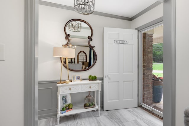 entryway featuring an inviting chandelier, light hardwood / wood-style floors, and crown molding