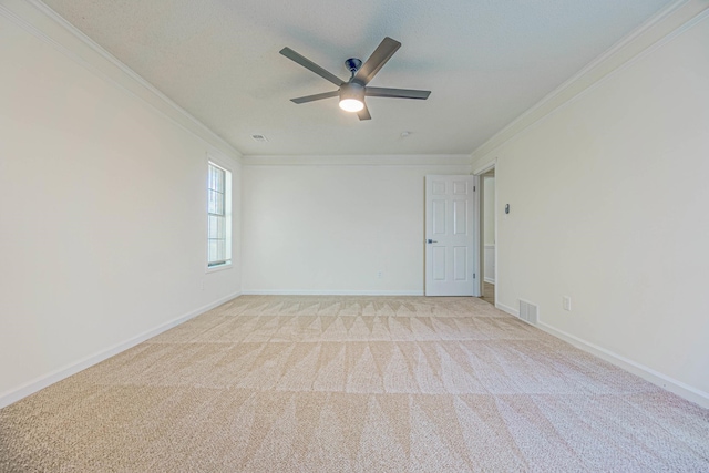 spare room featuring ornamental molding, ceiling fan, and light colored carpet