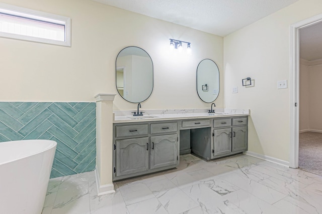 bathroom with a bathtub, a textured ceiling, and vanity