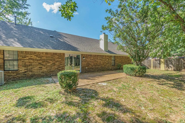 back of house with a lawn and a patio area