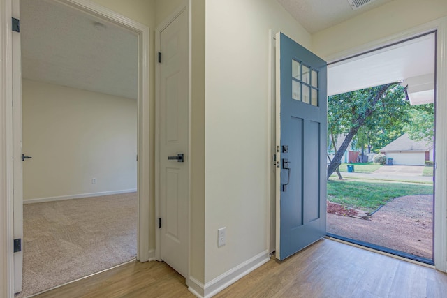 entrance foyer featuring light wood-type flooring and a textured ceiling