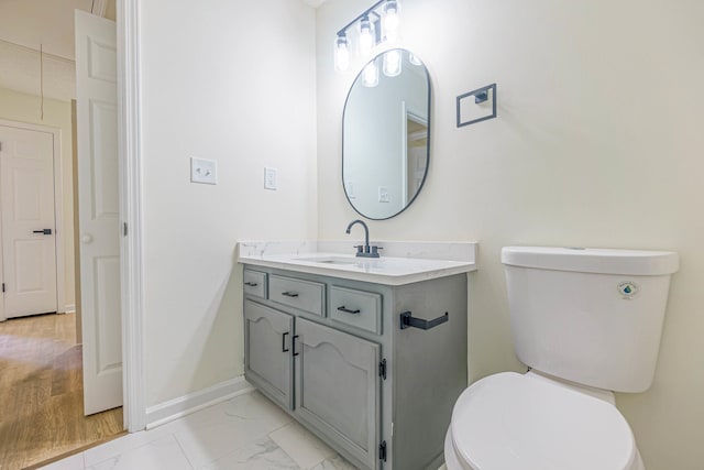 bathroom with vanity, toilet, and hardwood / wood-style flooring