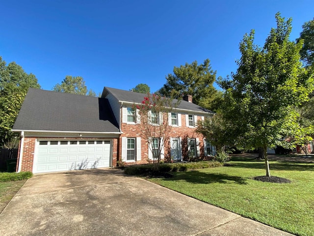 colonial-style house featuring a garage and a front yard