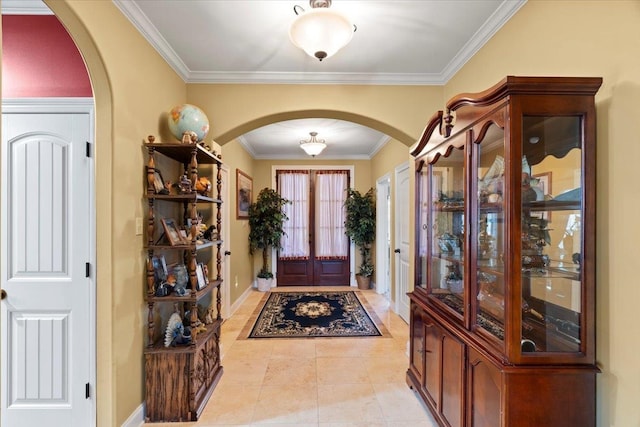 entryway with french doors, crown molding, and light tile patterned floors