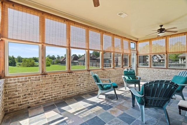 unfurnished sunroom with ceiling fan and a wealth of natural light