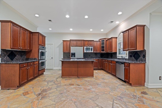 kitchen with dark stone countertops, stainless steel appliances, tasteful backsplash, and a kitchen island