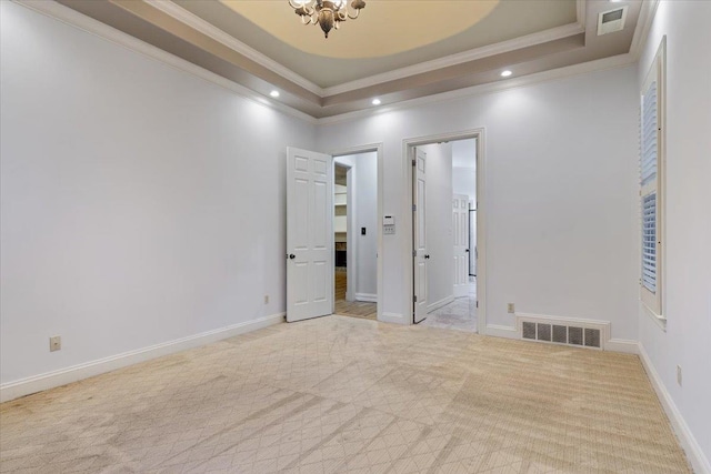 unfurnished bedroom featuring light colored carpet, an inviting chandelier, connected bathroom, a raised ceiling, and crown molding