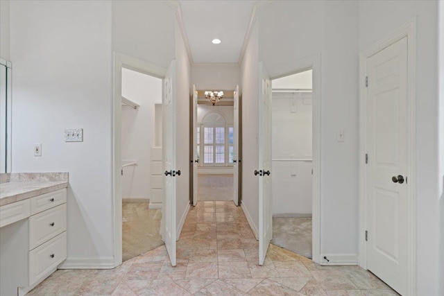 bathroom with ornamental molding, vanity, and a notable chandelier