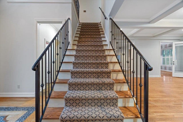 stairway featuring coffered ceiling, beamed ceiling, crown molding, and hardwood / wood-style floors