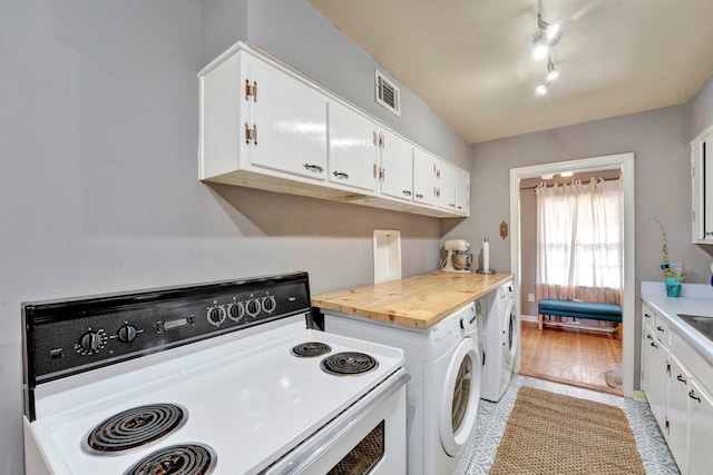 washroom featuring washing machine and dryer and light hardwood / wood-style floors