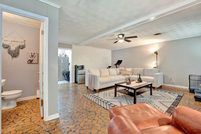 living room with beam ceiling, ceiling fan, and a textured ceiling