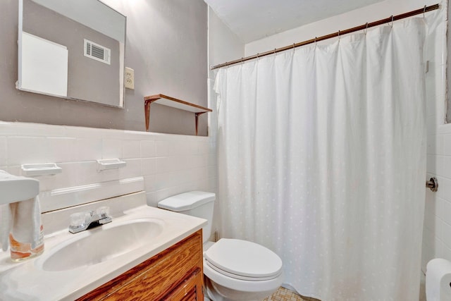 bathroom featuring curtained shower, tile walls, vanity, and toilet