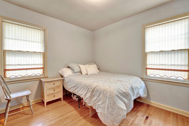 bedroom with light wood-type flooring and multiple windows