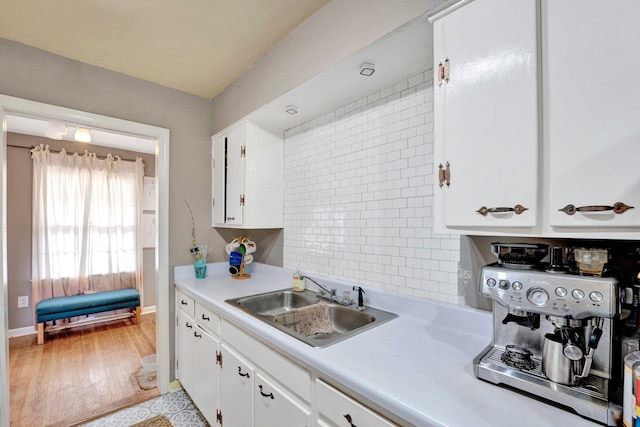 kitchen featuring light hardwood / wood-style floors, sink, and white cabinetry