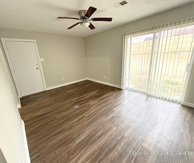 spare room featuring a textured ceiling, ceiling fan, and dark hardwood / wood-style flooring