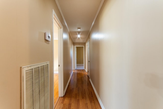 corridor with wood-type flooring and crown molding